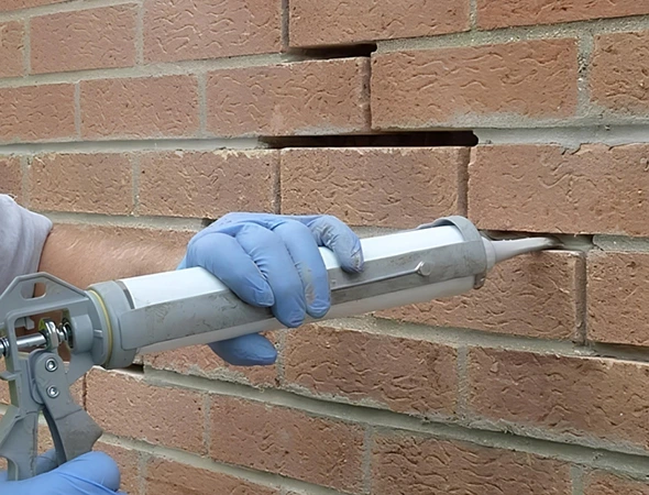 White cabinets with dark handles, a stainless steel oven and dishwasher, and a grey tile backsplash in a room with dark wood floors.