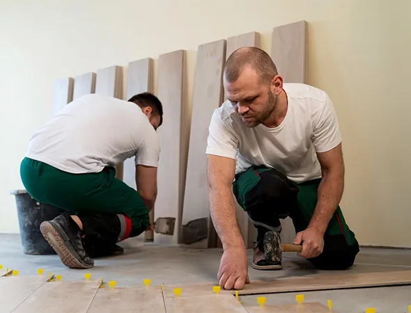 Local handyman in Fair Haven installing new tile flooring to fix chipped or uneven surfaces.
